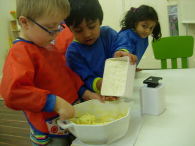 Pre-school children learning to cook at Early Learners' Nursery School, Leicester